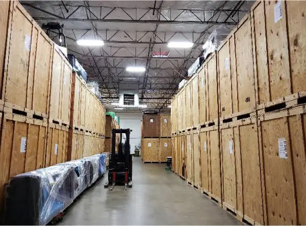 A forklift in an aisle of wooden boxes